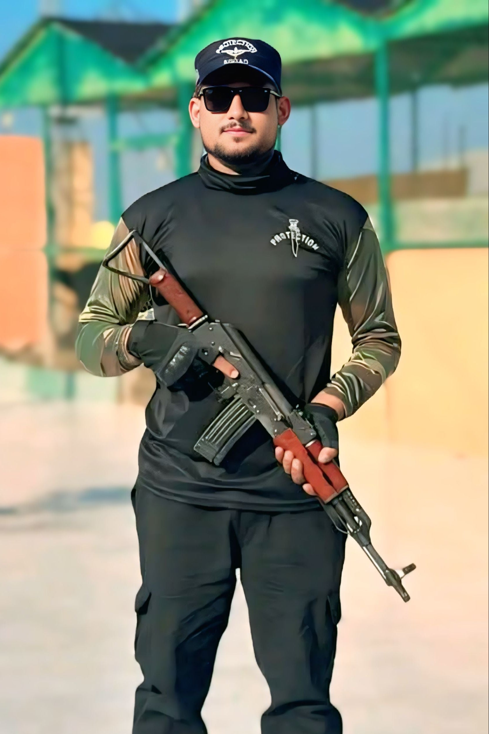 Person in tactical gear holding a rifle outdoors